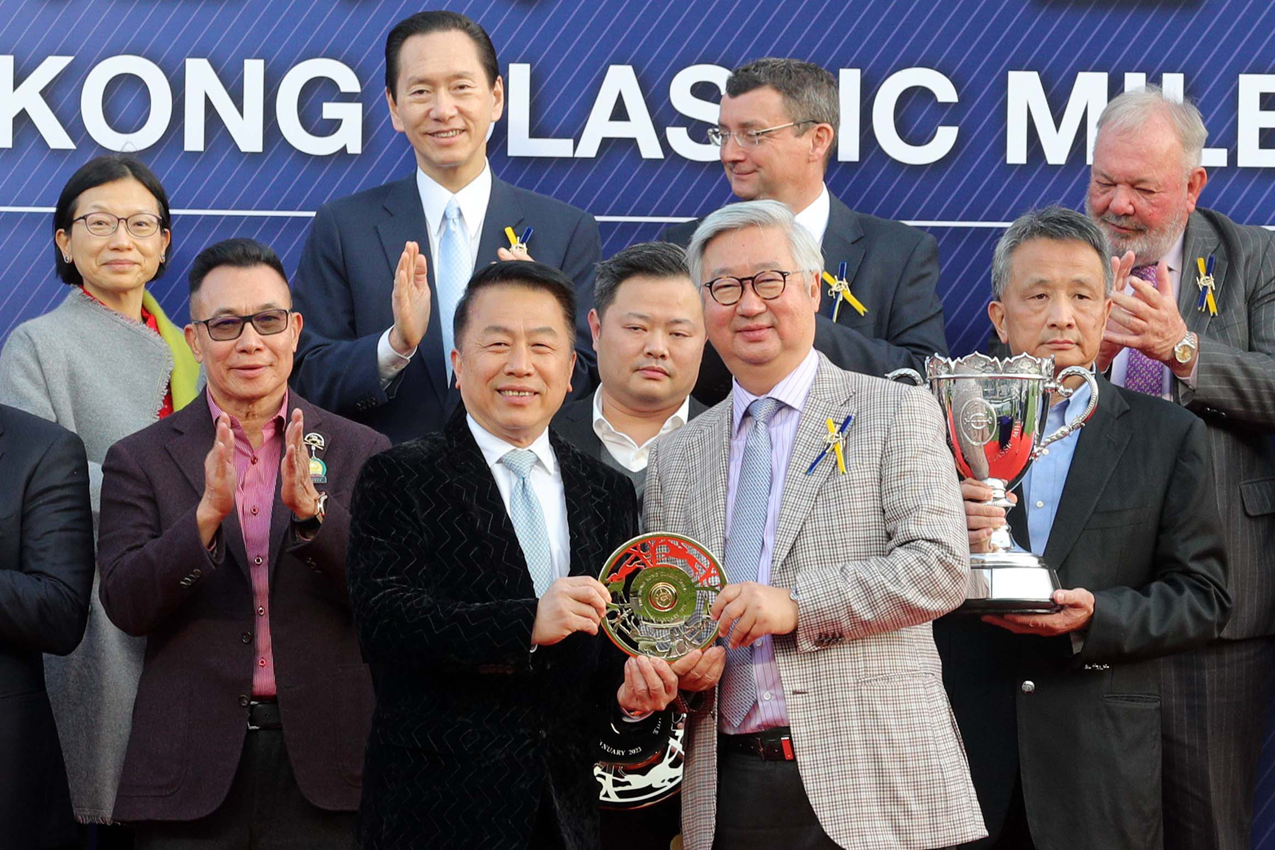 馬會董事楊紹信博士（右）在頒獎儀式上將香港經典一哩賽獎盃及鍍金碟頒予「遨遊氣泡」的馬主日月輝煌賽馬團體、練馬師姚本輝及騎師賈傑美。
