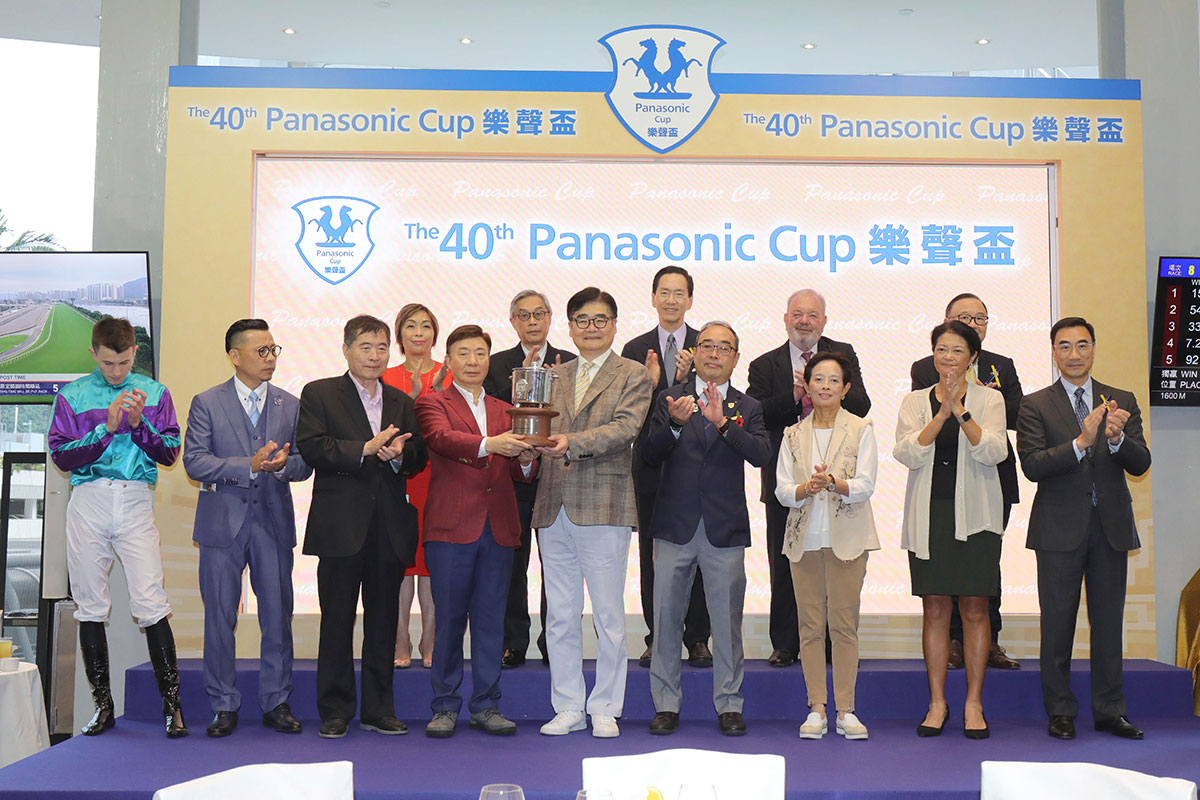 Panasonic Holdings Corporation集團副總裁本間哲朗先生（右）在頒獎禮上頒發樂聲盃予「美好世界」的馬主蘇凱榮。