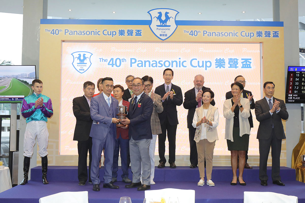 信興集團主席兼行政總裁蒙德揚博士（右）頒發獎盃予「美好世界」的練馬師羅富全。