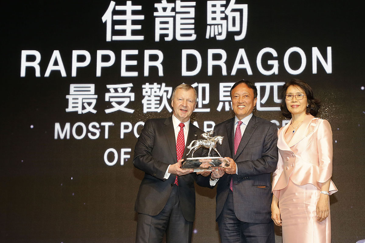 Mr. Winfried Engelbrecht-Bresges, CEO of HKJC, presents the Most Popular Horse of the Year award to Mr. Albert Hung Chao Hong, owner of Rapper Dragon, accompanied by his wife.