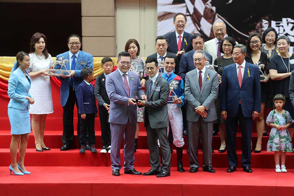 Dr. Allen Shi, President of the Hong Kong Racehorse Owners Association, presents the Most Improved Horse Award to Frankie Lor, Assistant Trainer for the John Size stable, representing Samuel Wong Yin Shun, owner of D B PIN.