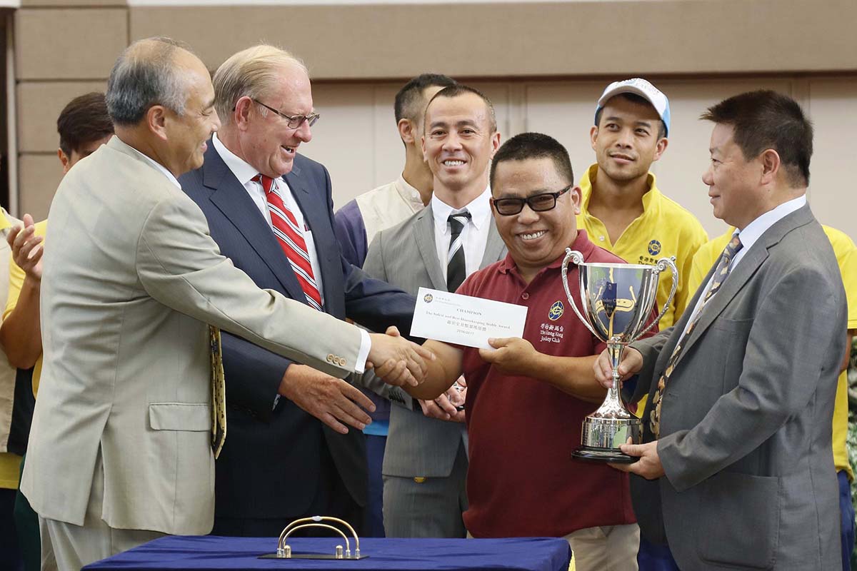 K L Cheng (left), Head of Racing Operations and Services, presents the stable prize to the representative of the stable staff of Manfred Man.