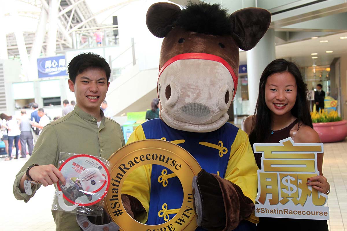 Racegoers receive complimentary “Celebrating the 20th Anniversary of Reunification” foldable souvenir fans upon entry.