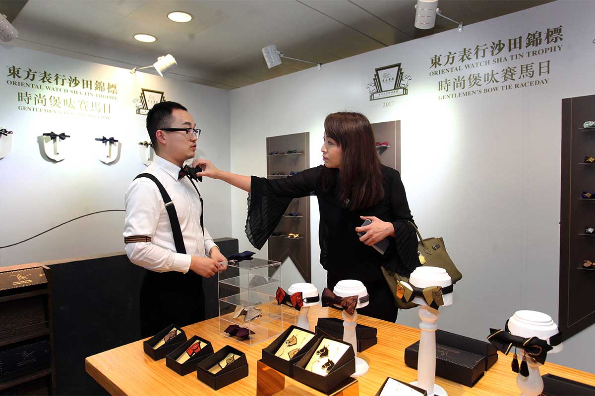 Male racegoers dress up in bow ties whereas ladies accessories their outfits with bow-shape to attend the annual Oriental Watch Sha Tin Trophy Gentlemen’s Bow-tie Day. Bow ties designed by up-and-coming Mainland China designer Weixu Wang and other accessories with equestrian and horological themes are sold at Sha Tin Racecourse today.