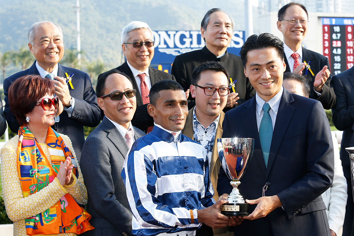 Mr. Oscar Chow Vee Tsung, Non-Executive Director of Chevalier International Holdings Limited, presents a replica trophy to winning jockey Karis Teetan.