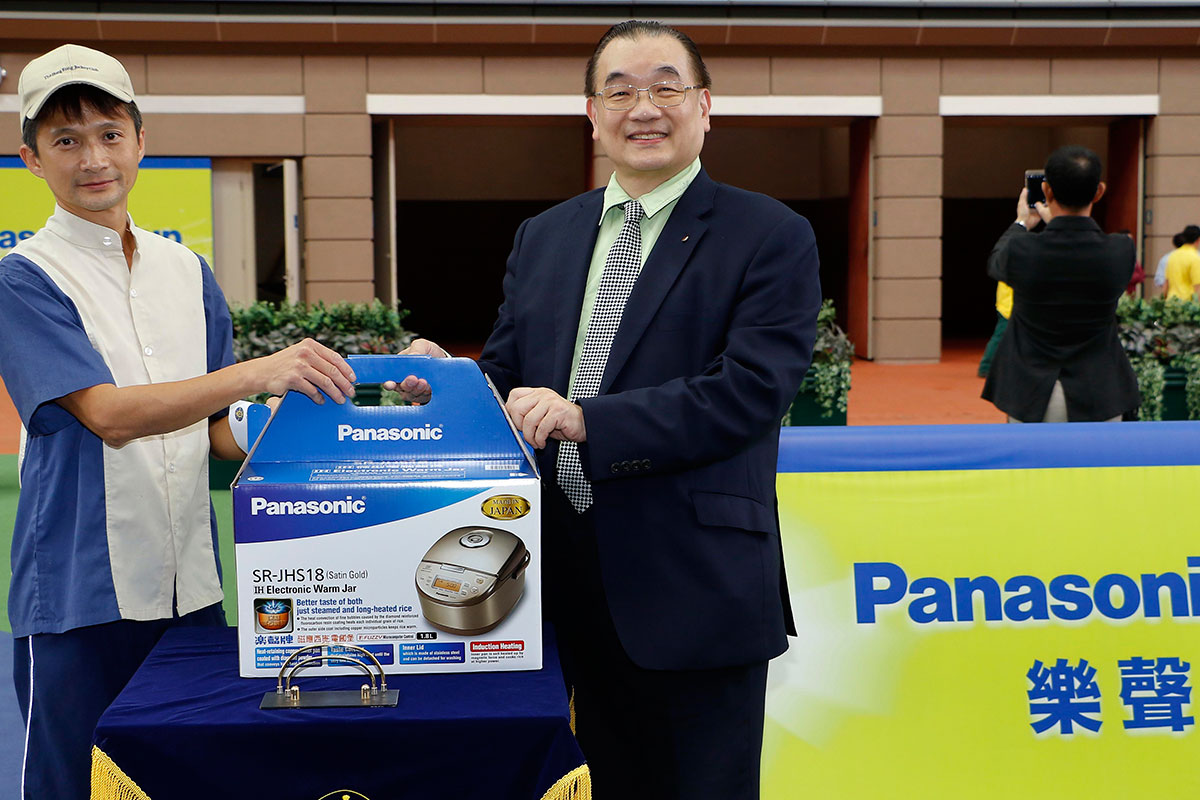 Terrence Chan, Vice Chairman of Shun Hing Group, presents a prize of HK$1,500 and a Panasonic IH Electronic Warm Jar to the Stables Assistant responsible for Racing Supernova, the best turned out horse in the Panasonic Cup.