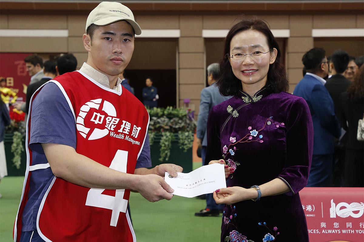 Ms Liu Saili, Deputy General Manager (right), Personal Banking and Wealth Management Department of the Bank of China (Hong Kong) Limited, presents a HK$2,000 prize to the stables assistant responsible for Beauty Generation, the best turned out horse in the BOCHK Wealth Management Jockey Club Mile.