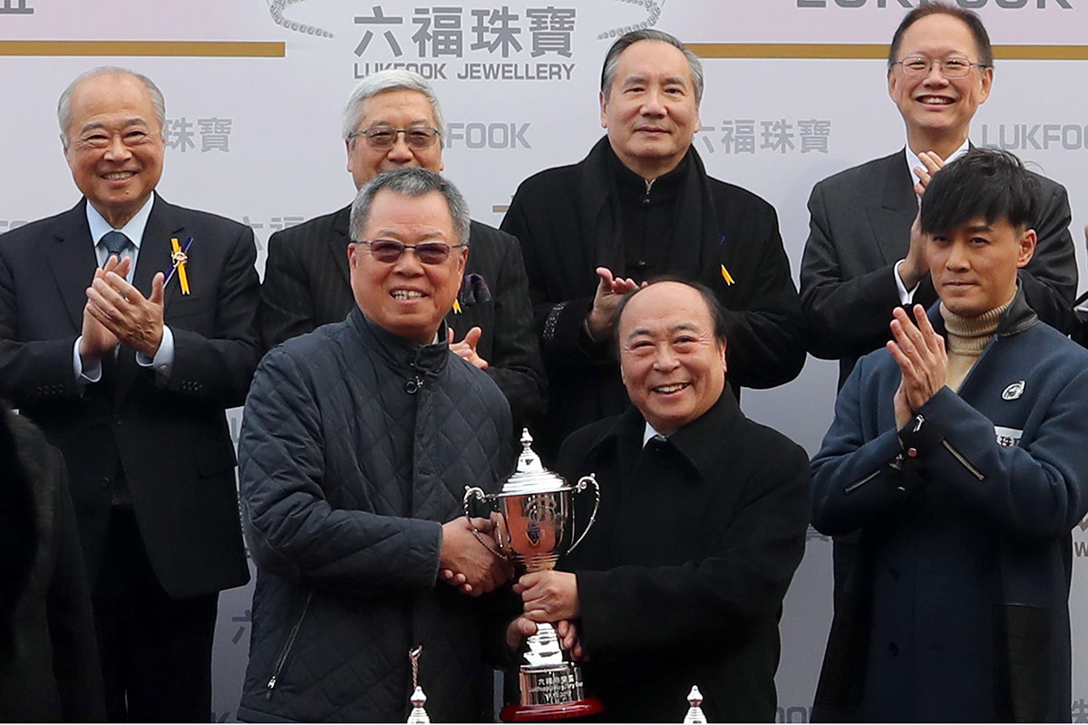 Wong Wai Sheung, Chairman and Chief Executive of Lukfook Group presents a Trophy to Yeung Kin Shan and Yeung Chi Ming, owners of winning horse New Elegance.