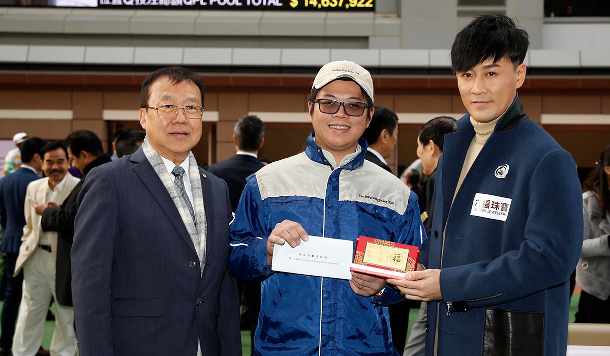 Tse Moon Chuen, Deputy Chairman and Deputy General Manager of Lukfook Group, and Raymond Lam, the spokesperson for the “Love Forever” collection of Lukfook Jewellery, jointly present a prize of HK$1,500 and a Gold Bar to the Stables Assistant responsible for Roundabout, the Best Turned Out Horse in the Lukfook Jewellery Cup.