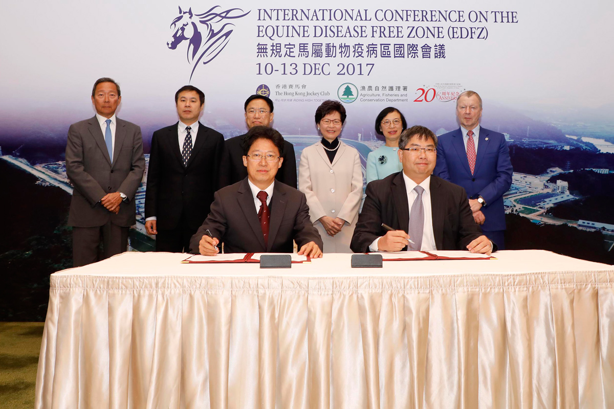 Mr Yang Guohai, Vice Director-General of Guangdong Entry-Exit Inspection and Quarantine Bureau, the People’s Republic of China (left of the front row) and Dr Leung Siu Fai, Director of Agriculture, Fisheries and Conservation of the Hong Kong SAR (right of the front row) sign the “Memorandum of Understanding Concerning the Support of Guangzhou Racecourse as a Key Project and the Joint Promotion of Horseracing Related Industries in Greater Bay Area” (《關於支持廣州馬場重點項目建設共同推動粵港澳大灣區賽馬相關產業發展合作備忘錄》). The signing is witnessed by (from left of the back row) Dr Simon S O Ip, Chairman of the Hong Kong Jockey Club; Mr Li Jianwei, Director-General of Department of Supervision on Animal and Plant Quarantine, the People’s Republic of China; Mr Li Yuanping, Vice Minister of the General Administration of Quality Supervision, Inspection and Quarantine, the People’s Republic of China; Mrs Carrie Lam, Chief Executive of the Hong Kong SAR; Professor Sophia Chan, Secretary for Food and Health of the Hong Kong SAR; and Mr Winfried Engelbrecht-Bresges, Chief Executive Officer of the Hong Kong Jockey Club.