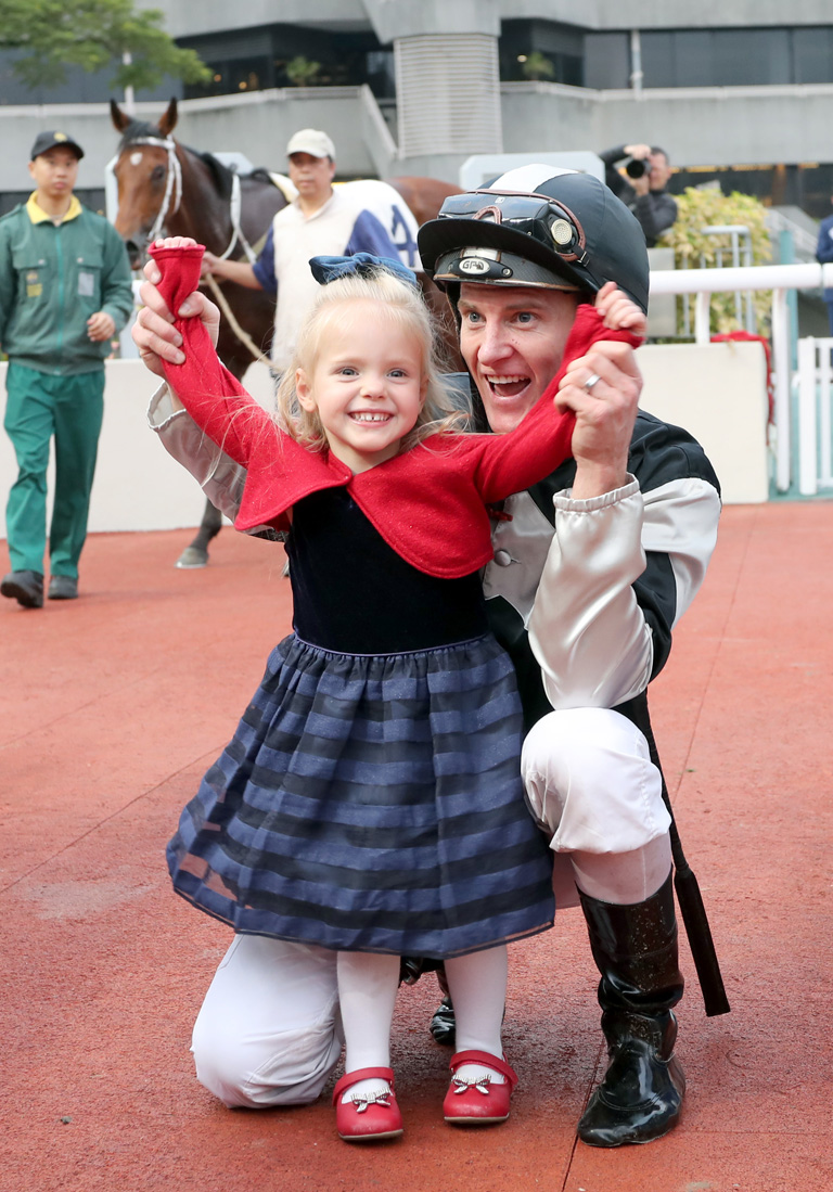 Zac Purton celebrates his treble, culminating in his win aboard Exultant, with daughter Roxy in the Sha Tin winners’ circle.