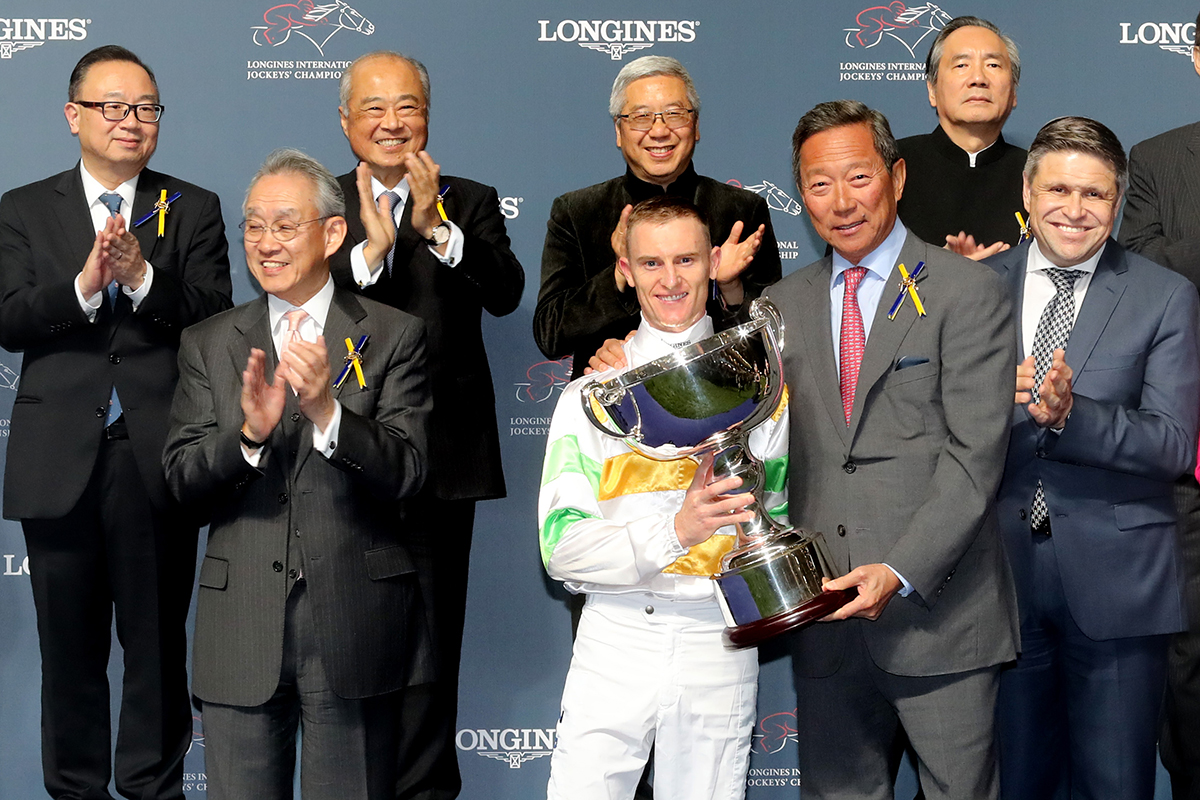 Dr Simon S O Ip (second from right), Chairman of the HKJC, presents the trophy, a silver whip and cash prize of HK$500,000 to Zac Purton, winner of the LONGINES International Jockeys Championship.