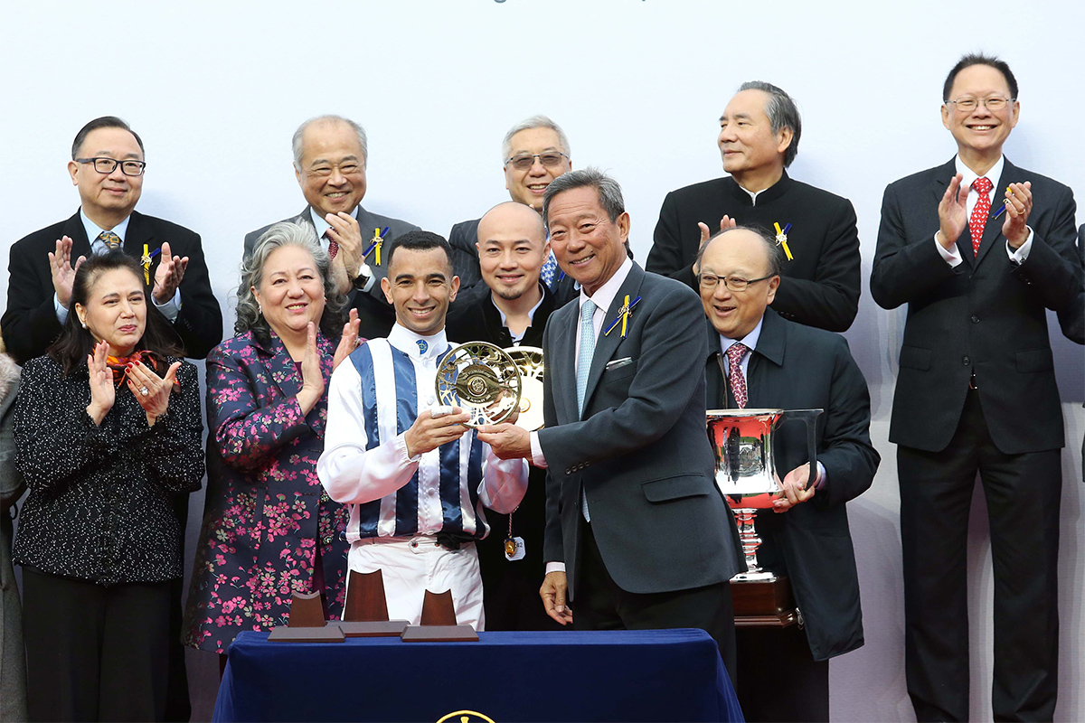 At the presentation ceremony, Club Chairman Dr Simon Ip (right) presents the Stewards’ Cup trophy and gold-plated dishes to Paul Lo Chung Wai, owner of Seasons Bloom, as well as winning trainer Danny Shum and jockey Joao Moreira.