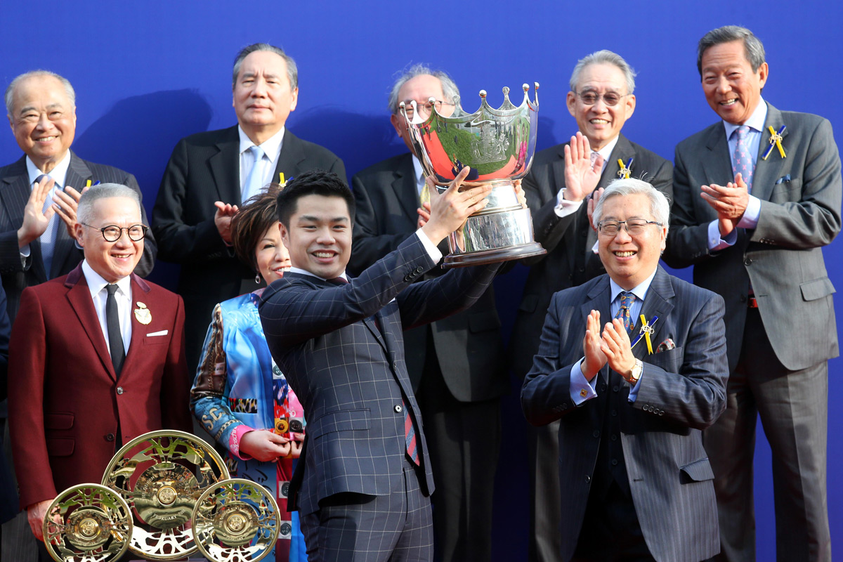 At the trophy presentation ceremony, Club Steward Dr Eric Li Ka Cheung (right) presents the Queen’s Silver Jubilee Cup trophies to Patrick Kwok, owner of Beauty Generation, trainer John Moore and jockey Zac Purton.