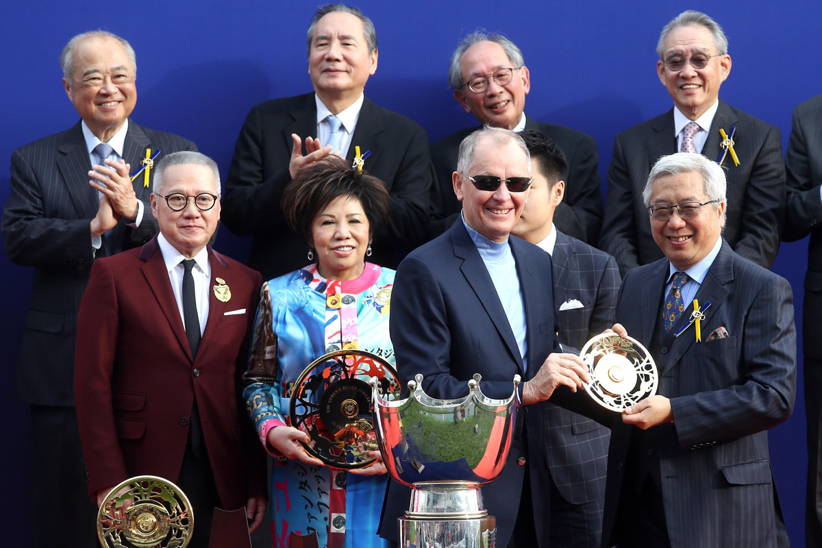 At the trophy presentation ceremony, Club Steward Dr Eric Li Ka Cheung (right) presents the Queen’s Silver Jubilee Cup trophies to Patrick Kwok, owner of Beauty Generation, trainer John Moore and jockey Zac Purton.