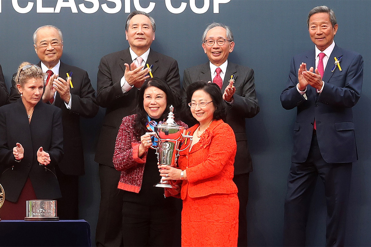 At the trophy presentation ceremony, Club Steward Margaret Leung (right) presents the Hong Kong Classic Cup trophy and gold-plated dishes to Singapore Sling’s owner representative, trainer Tony Millard and jockey Chad Schofield.