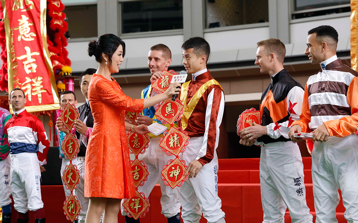 Jockeys greet fans at the opening ceremony and wish them good fortune and prosperity in the Year of the Dog.