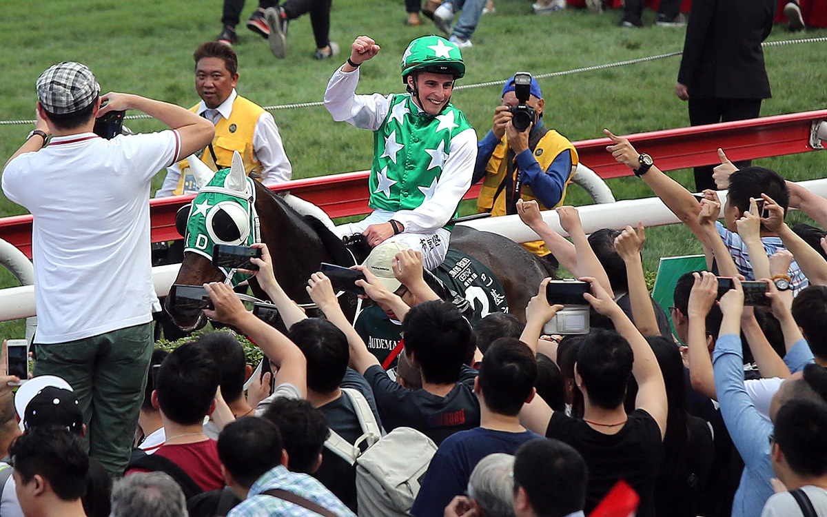 Jockey William Buick celebrates his success with the Sha Tin crowd after the race.