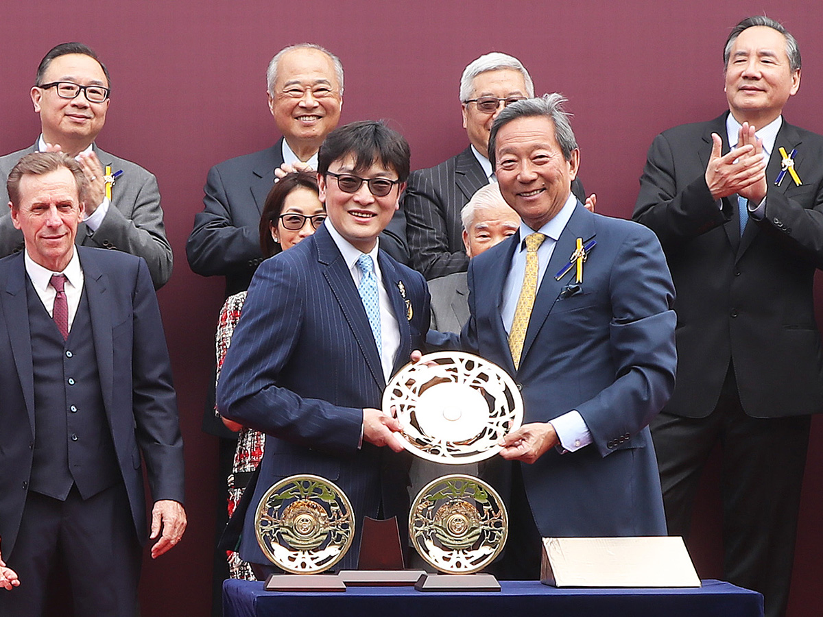 Dr Simon Ip, Chairman of HKJC, presents the Chairman’s Sprint Prize trophy to Mrs Michael T H Lee, owner representative of Ivictory and gold-plated dishes to Dr Henry Chan Hin Lee, owner of Ivictory, winning trainer John Size and jockey Zac Purton.