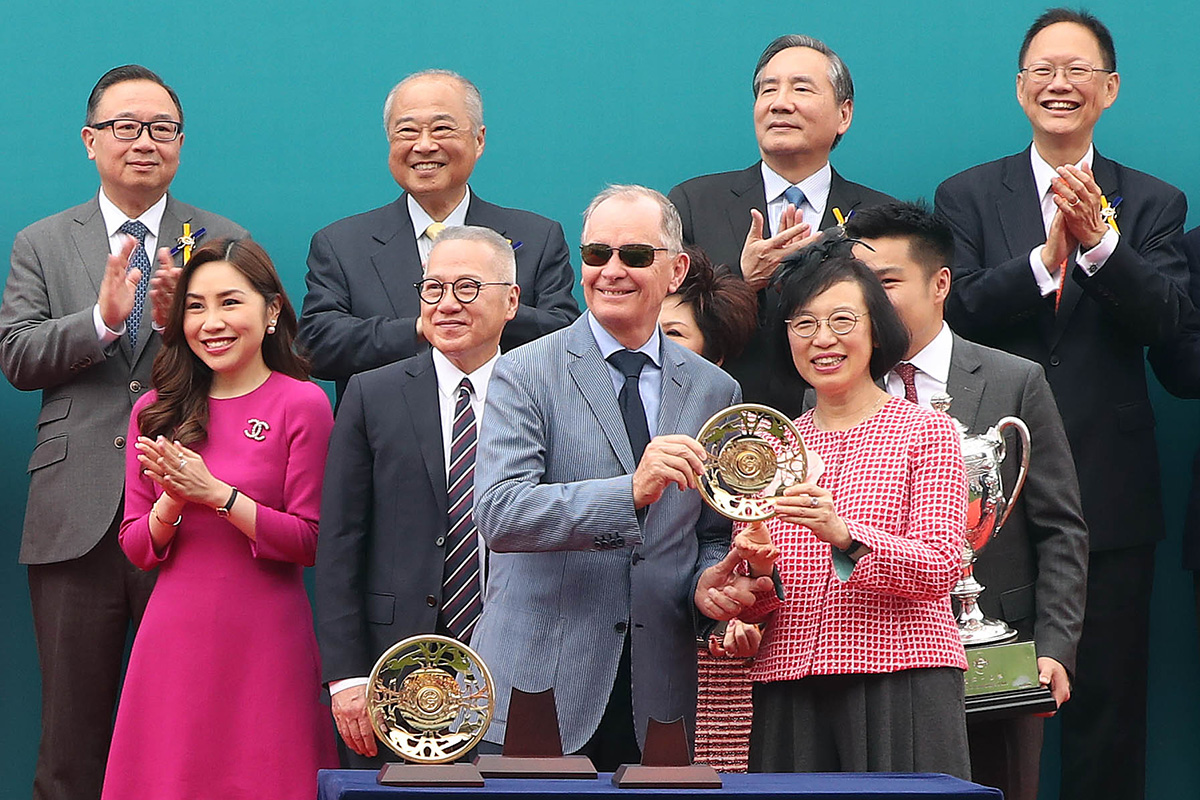 Professor the Hon. Sophia Chan Siu-chee, Secretary for Food and Health of the Government of the HKSAR, presents the Champions Mile trophy and gold-plated dishes to Patrick Kwok Ho Chuen, owner of Beauty Generation, winning trainer John Moore and jockey Zac Purton.