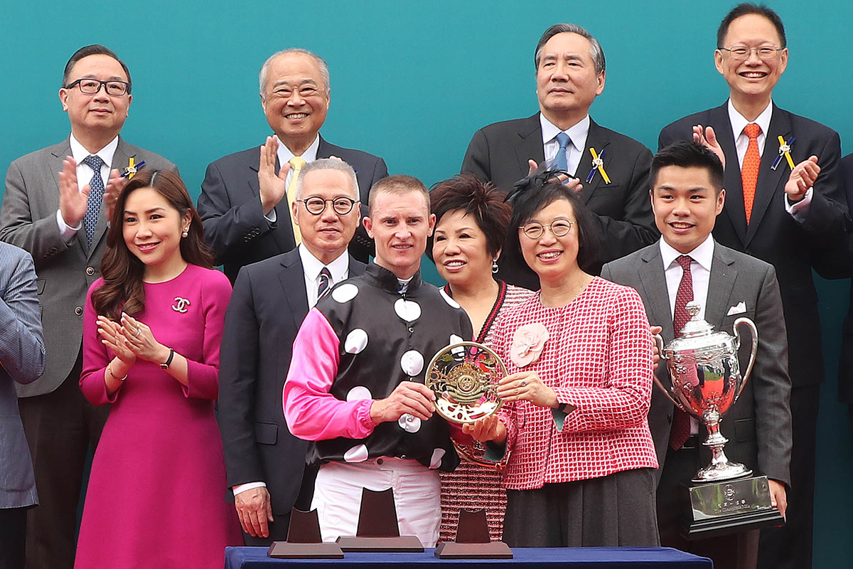 Professor the Hon. Sophia Chan Siu-chee, Secretary for Food and Health of the Government of the HKSAR, presents the Champions Mile trophy and gold-plated dishes to Patrick Kwok Ho Chuen, owner of Beauty Generation, winning trainer John Moore and jockey Zac Purton.