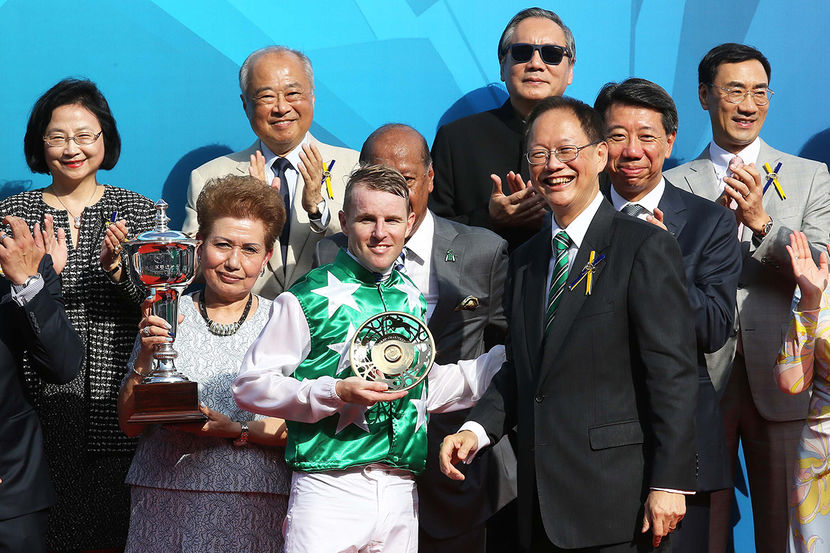 Philip Chen, Steward of the Hong Kong Jockey Club, presents gold-plated dishes to winning trainer Tony Cruz and jockey Tommy Berry.