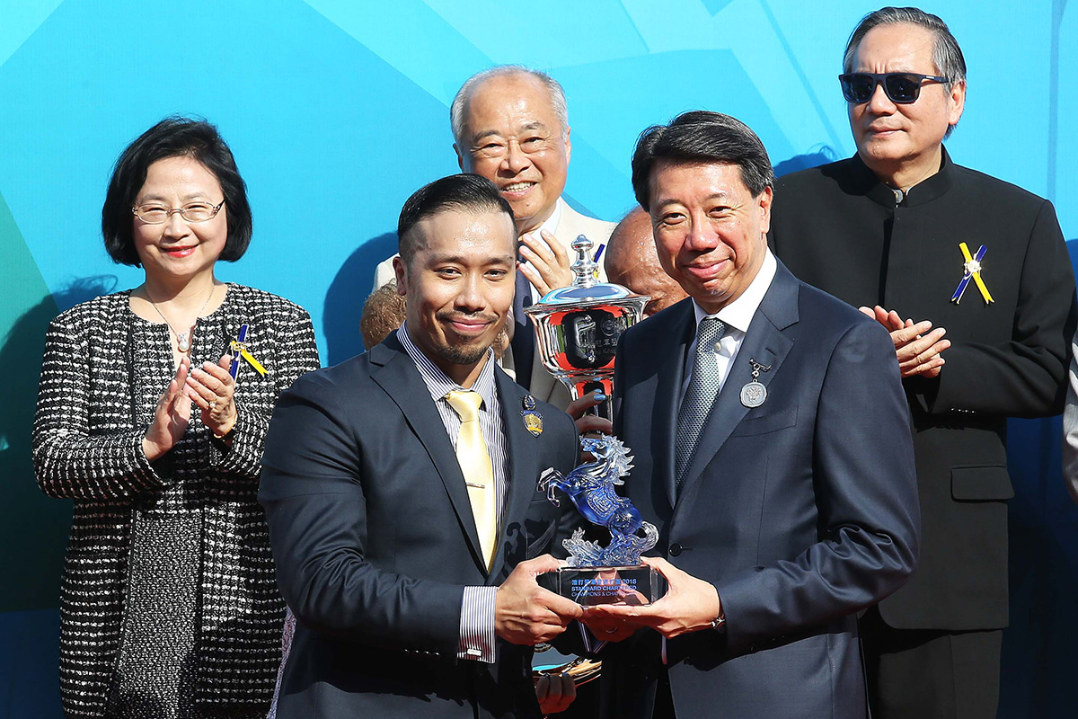 Benjamin Hung, Regional Chief Executive Officer, Greater China & North Asia and Chief Executive Officer, Retail Banking & Wealth Management of Standard Chartered Bank, presents a souvenir to the representative of the winning owner and jockey Tommy Berry.