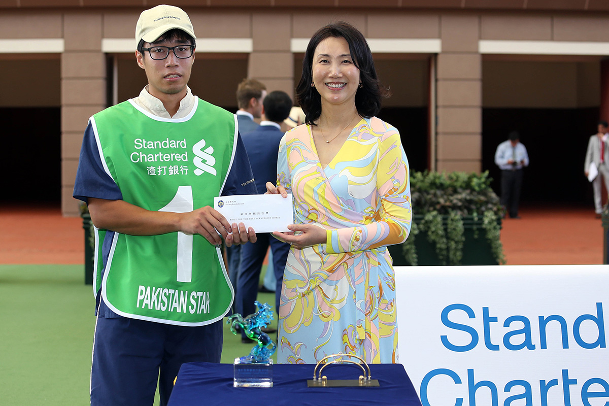 Before the race, Mary Huen, Chief Executive Officer of Standard Chartered Bank (Hong Kong) Limited, presents a HK$5,000 prize and a souvenir to the Stables Assistant responsible for Pakistan Star, the Best Turned-Out Horse for the Standard Chartered Champions & Chater Cup.
