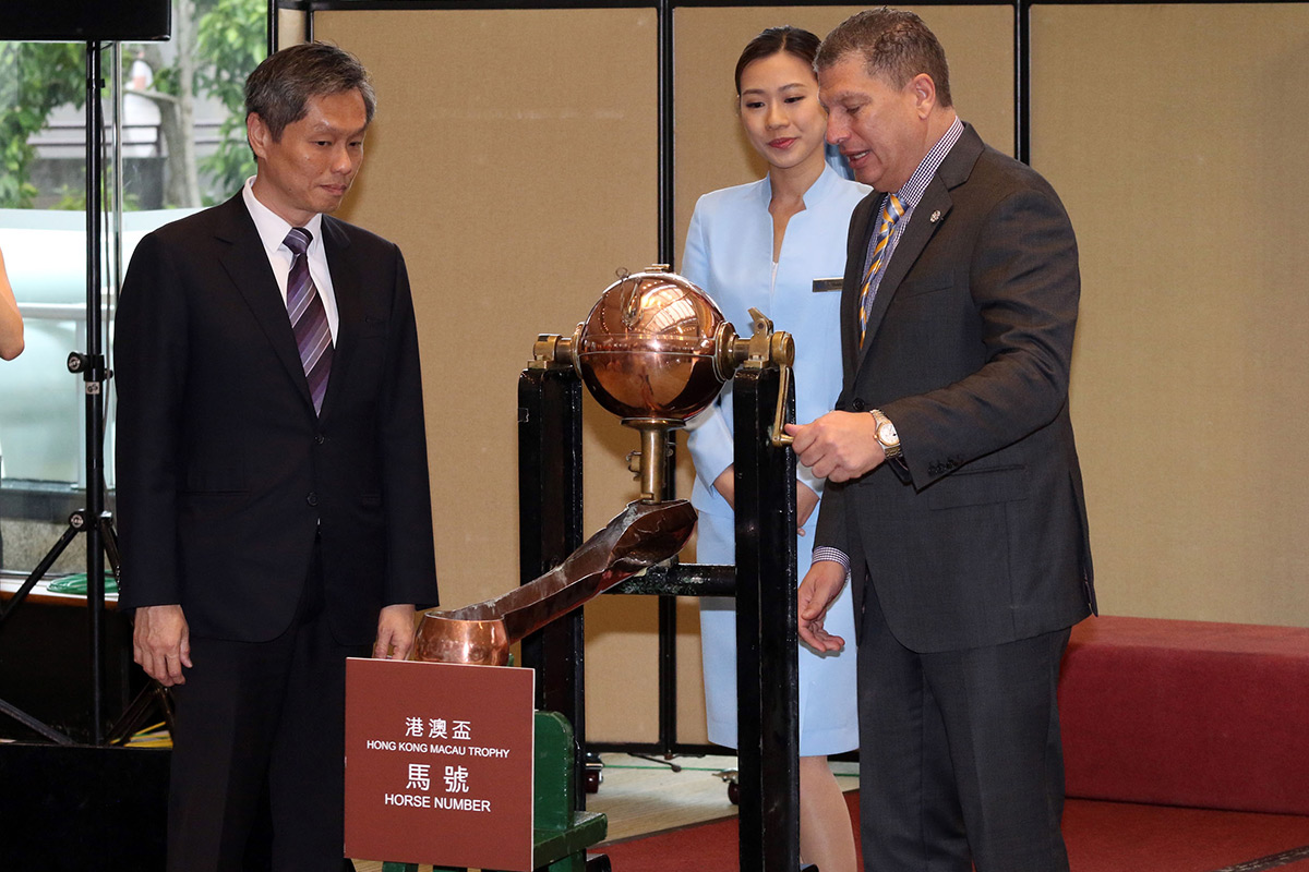 William Nader, Director of Racing Business & Operations of the Hong Kong Jockey Club (right), and Kwang Eng Seong, Operations Controller of the Macau Jockey Club (left), jointly draw the number of the first horse at the 2018 Hong Kong Macau Trophy barrier draw ceremony at Sha Tin racecourse this morning.