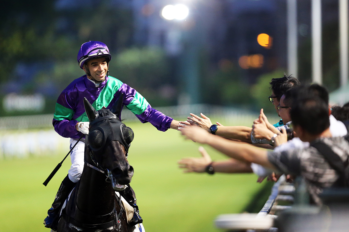 Joao Moreira celebrates with fans on the track after winning the opening race on the David Hall-trained Penzance.