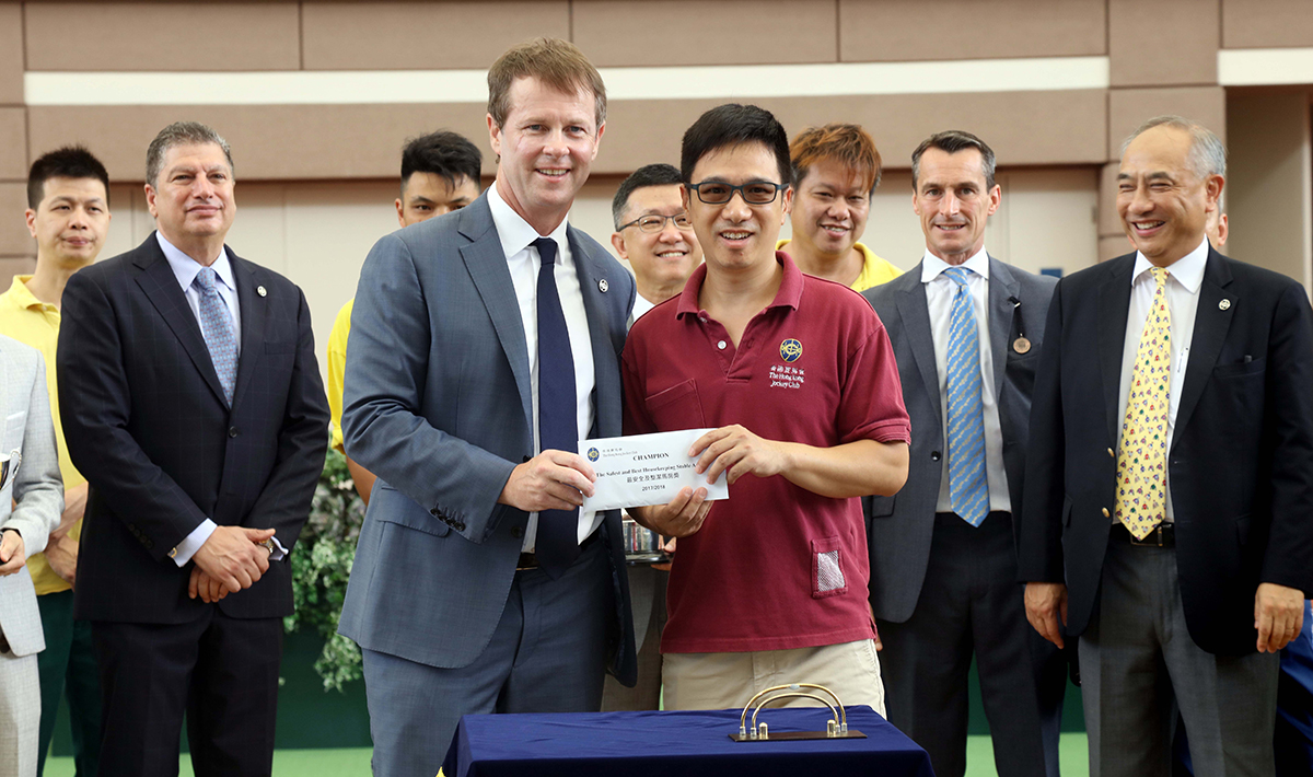 Mr. Andrew Harding, the Club's Executive Director, Racing presents the stable prize to the representative of the stable staff of Peter Ho.