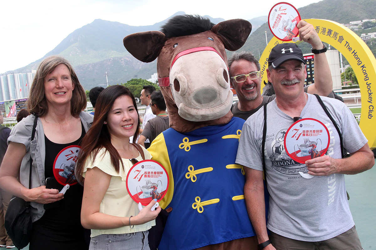 Racegoers receive “Celebrating the Anniversary of Reunification” souvenir fans upon entry.
