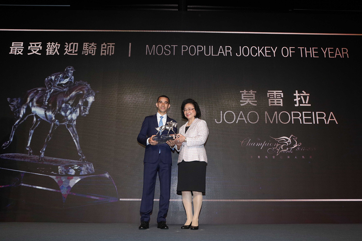 Joao Moreira receives the Most Popular Jockey of the Year trophy from Mrs. Margaret Leung, Steward of HKJC.
