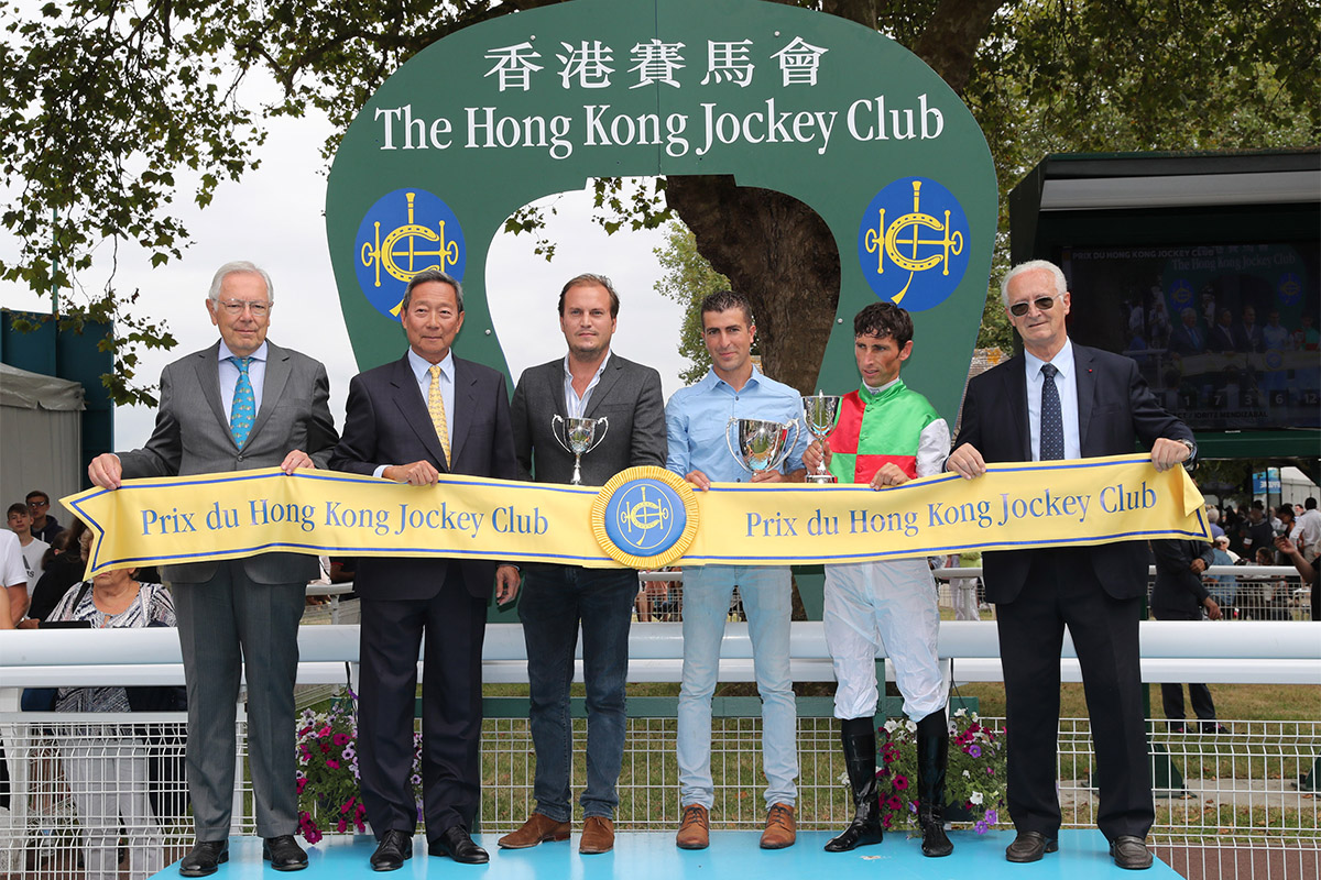 Hong Kong Jockey Club Chairman Dr. Simon Ip (second from left), accompanied by Jean-Pierre Colombu (first from left), Vice President of France Galop and Louis Romanet (first from right), Chairman of the International Federation of Horseracing Authorities (IFHA), presents the Prix du Hong Kong Jockey Club trophy to the winning connections of Prima Perfect.
