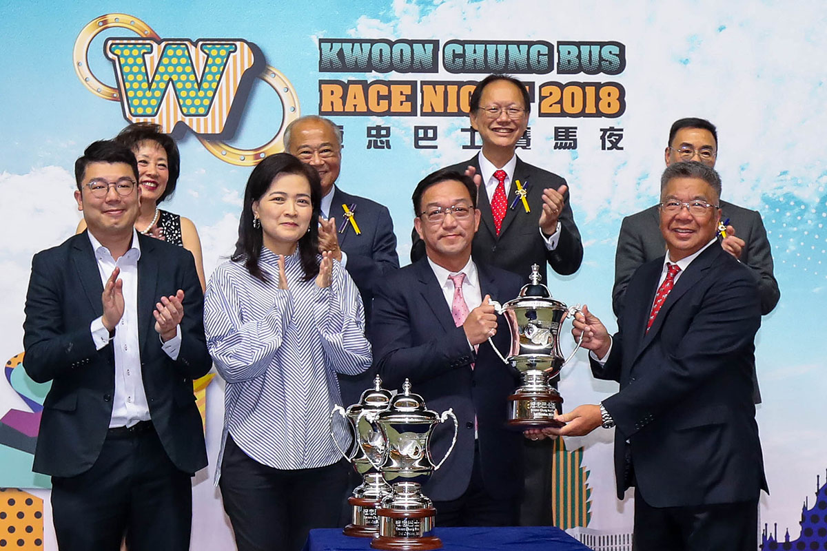 Matthew Wong BBS, Chairman of Kwoon Chung Bus Holdings Limited, accompanied by his wife, Christina Wong, presents the Kwoon Chung Bus Cup trophy to the Hon. and Mrs. Kenneth Lau Ip Keung, the owners of winning horse Insayshable.