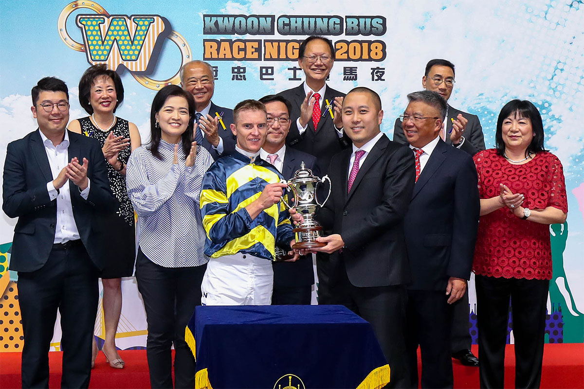 Marco Lo, Executive Director of Kwoon Chung Bus Holdings Limited, presents the trophy to winning jockey Zac Purton.