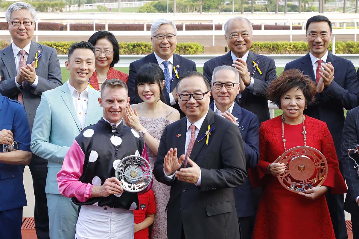 The Hon Martin Liao (front row, 1st from right), Steward of the Club, presents the winning trophy and silver dishes to Owner Patrick Kwok Ho Chuen and his family, Trainer John Moore and Jockey Zac Purton of Beauty Generation, winner of the Celebration Cup.
