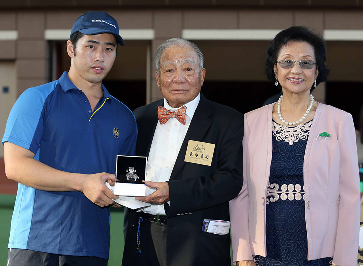Chairman of the Oriental Watch Holdings Limited Dr. Yeung Ming Biu, accompanied by his wife, presents a prize of HK$2,000 and a watch to the Stables Assistant responsible for Beauty Generation, the Best Turned Out Horse in the Oriental Watch Sha Tin Trophy.