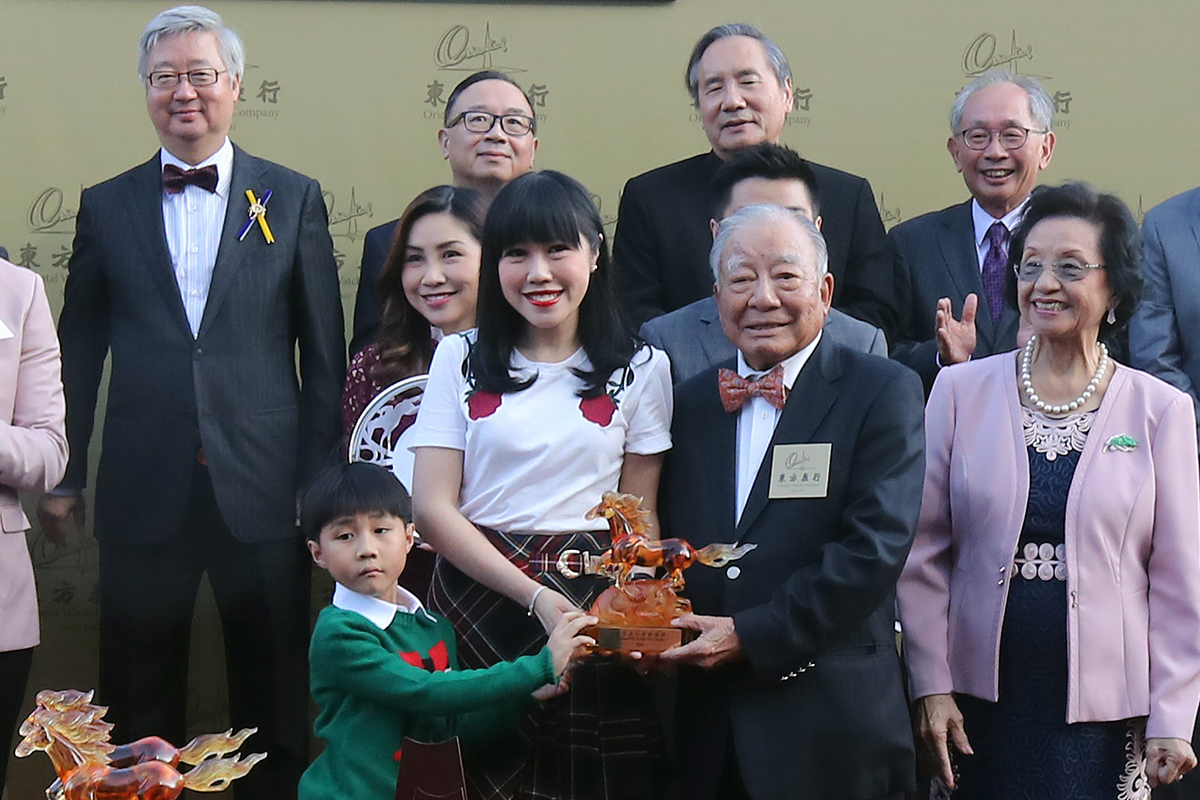 Chairman of the Oriental Watch Holdings Limited Dr. Yeung Ming Biu, accompanied by his wife, presents a souvenir to the owner representative.