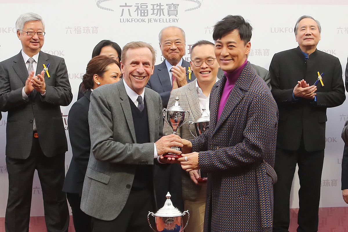 Raymond Lam, the spokesperson for the “Love Forever” collection of Lukfook Jewellery, presents a miniature to the winning trainer John Size and jockey Joao Moreira.