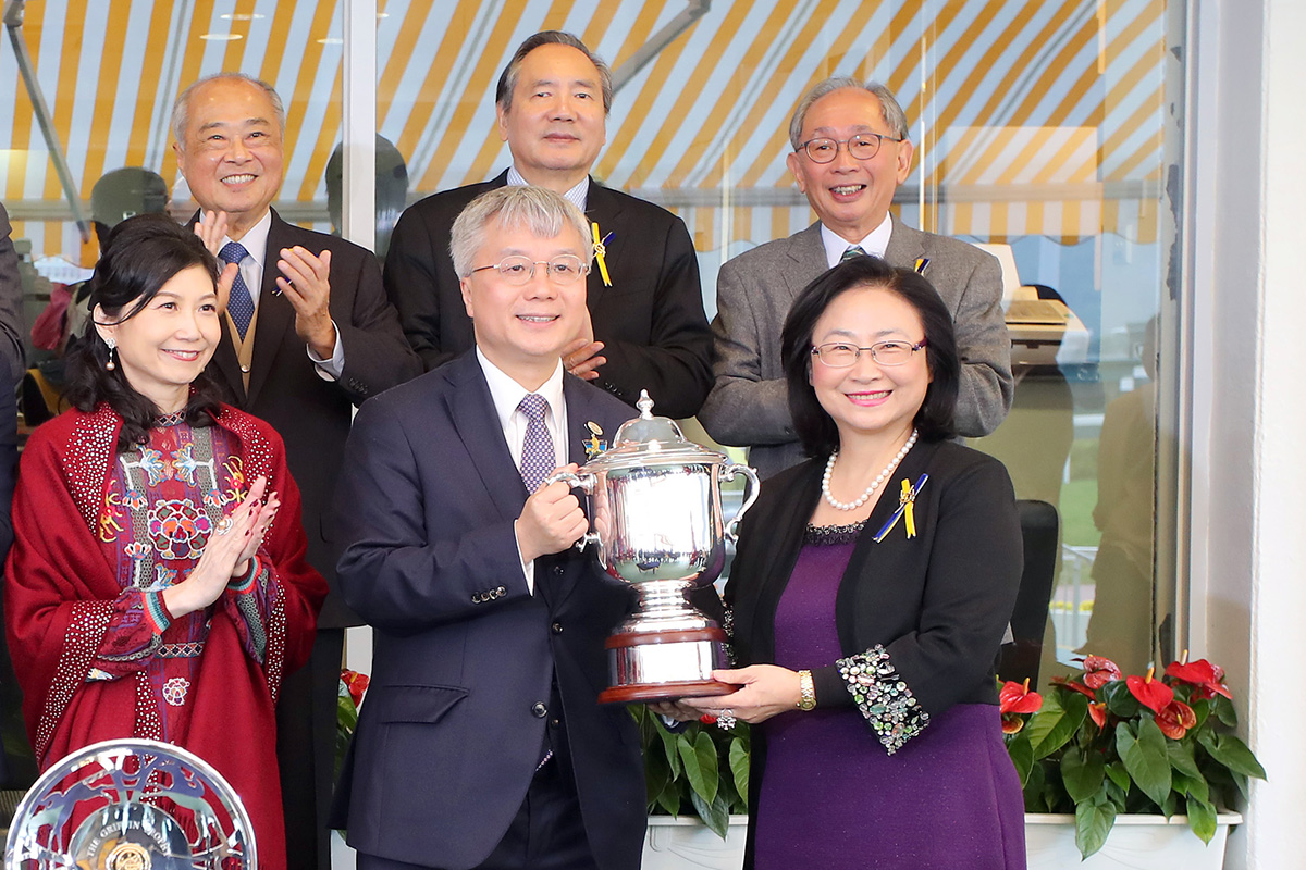At the trophy presentation ceremony, Club Steward Margaret Leung presents the Griffin Trophy and a silver dish to Mr & Mrs Peter Kung, owner of Perfect Match, trainer Danny Shum and jockey Karis Teetan.
