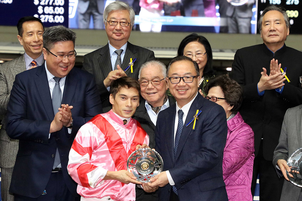 The Hon Martin Liao, Steward of the Club, presents silver dishes to jockey Alexis Badel.