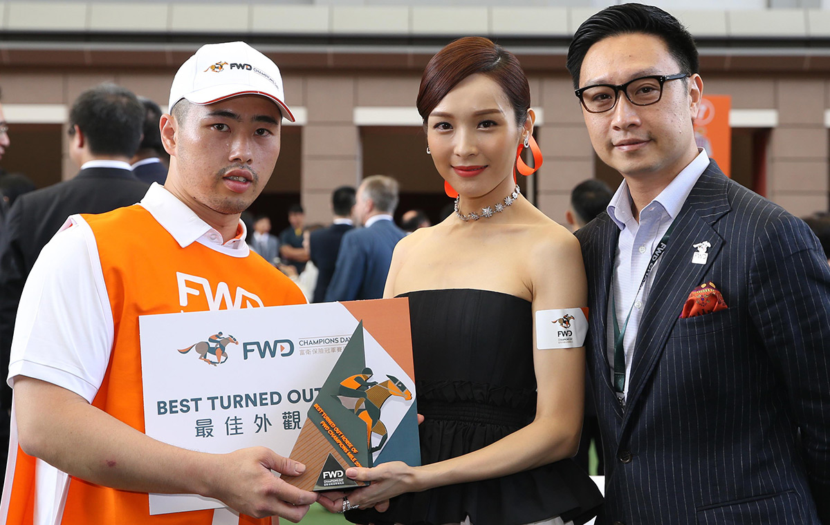 Mr Paul Tse, Chief Marketing Officer, FWD Hong Kong and Macau, and Ms Ali Lee, FWD Champions Day Ambassador, present a prize of HK$5000 and a souvenir to the Stable Assistant responsible for Beauty Generation, the best turned out horse for the FWD Champions Mile.
