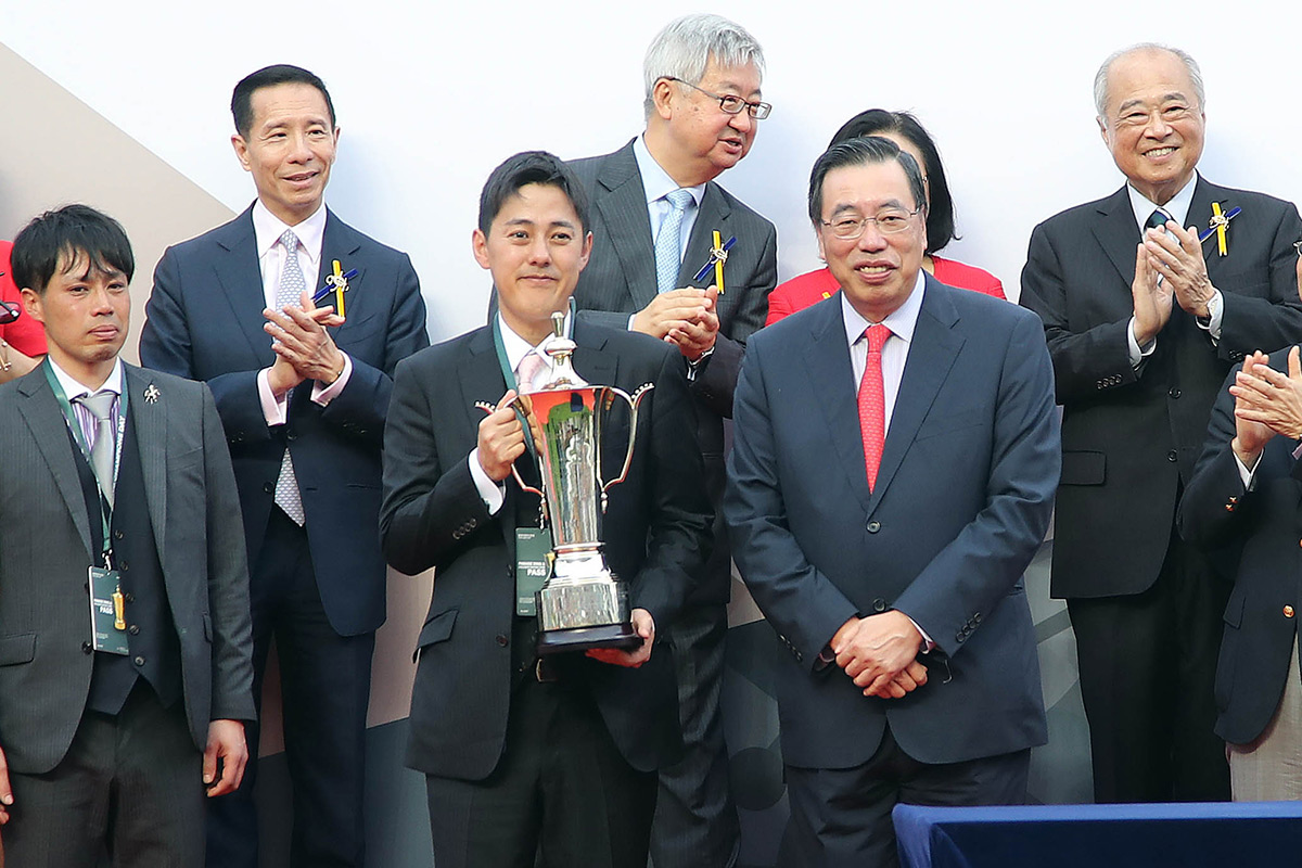 At the FWD QEII Cup trophy presentation ceremony, The Hon Andrew Leung Kwan-yuen (right), GBS, JP, The President of the Legislative Council of the HKSAR, presents the winning trophy to Win Bright’s owner representative, trainer Yoshihiro Hatakeyama and jockey Masami Matsuoka.