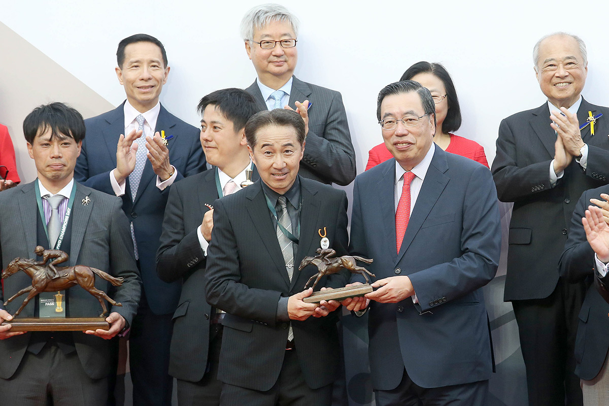At the FWD QEII Cup trophy presentation ceremony, The Hon Andrew Leung Kwan-yuen (right), GBS, JP, The President of the Legislative Council of the HKSAR, presents the winning trophy to Win Bright’s owner representative, trainer Yoshihiro Hatakeyama and jockey Masami Matsuoka.
