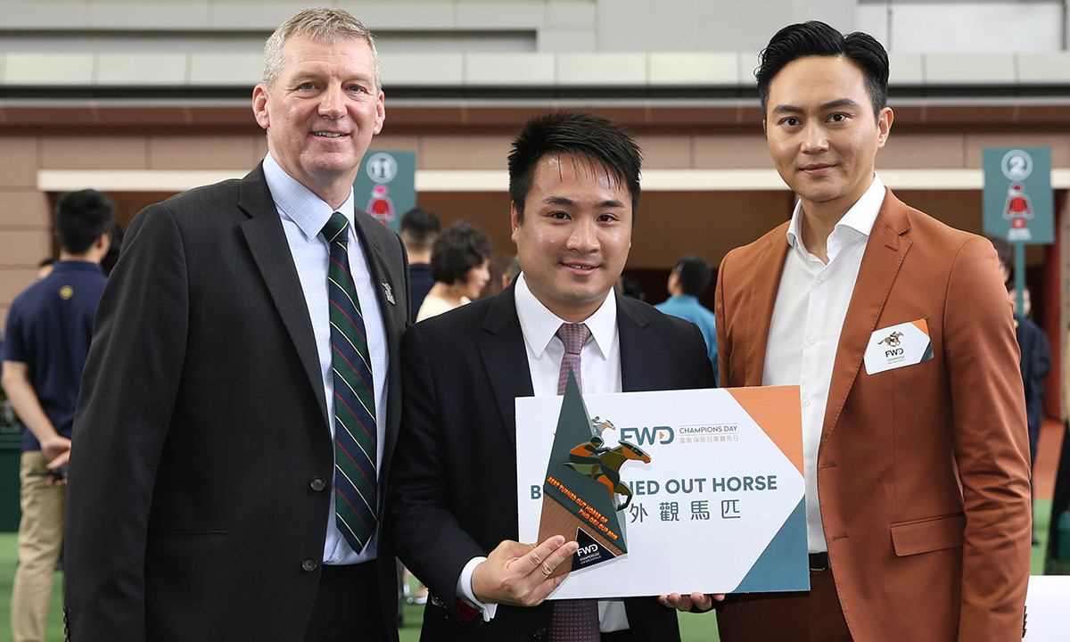 Mr Tim Oliver(left), Chief Customer and Marketing Officer, FWD Group, and Mr Chi-lam Cheung(right), FWD Champions Day Ambassador, jointly present a cash prize and a souvenir to the representative of Stables Assistant responsible for Eminent, the Best Turned Out Horse before the FWD QEII Cup.
