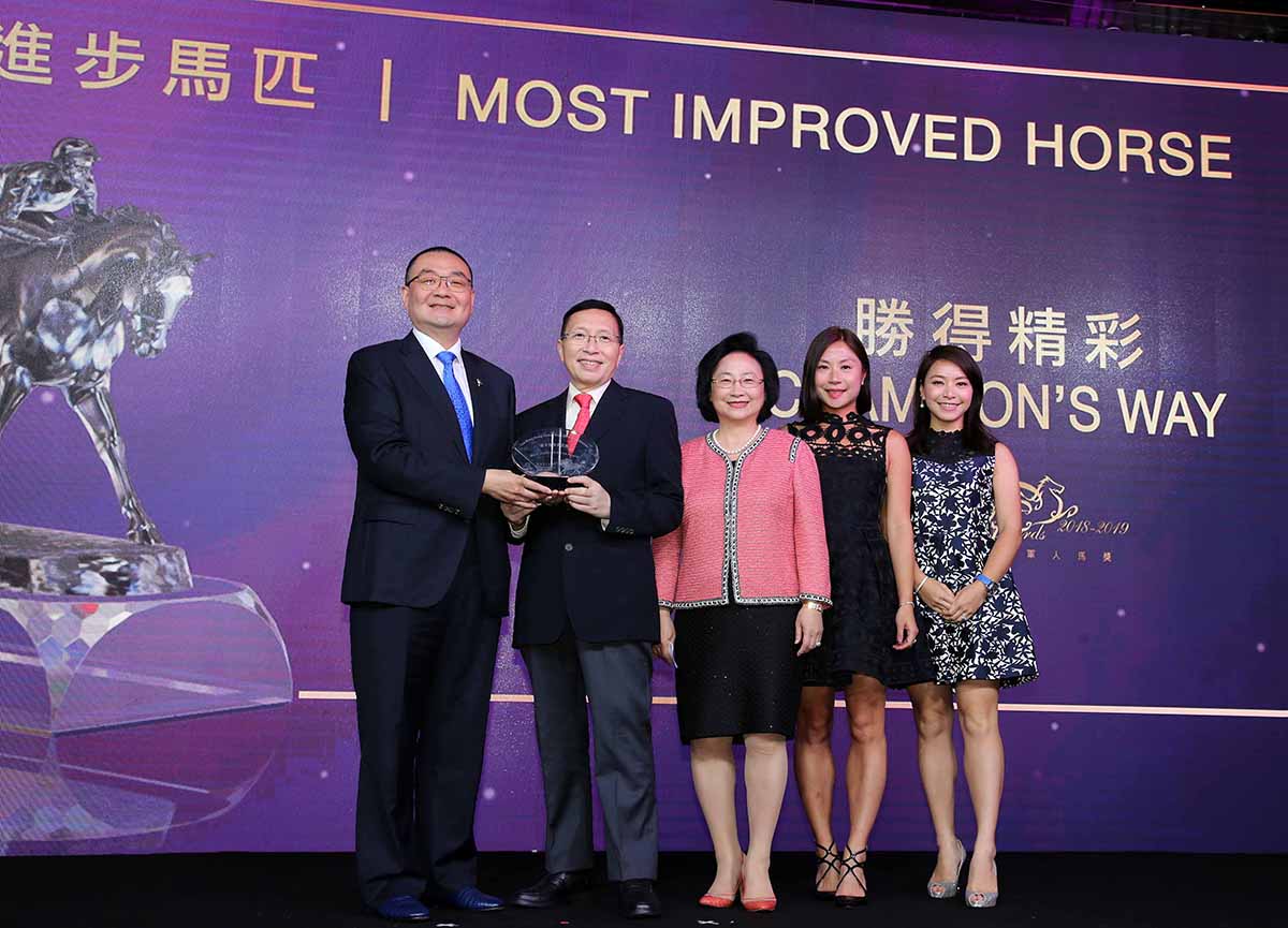 Mr. Benson Lo, President of the Hong Kong Racehorse Owners Association, presents the Most Improved Horse trophy to Dr & Mrs Arthur Leung, Elaine Leung and Angela Leung, owners of Champion’s Way.
