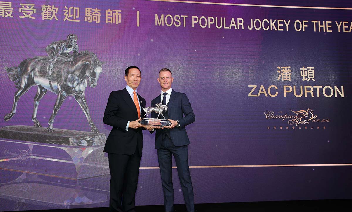 Zac Purton receives the Most Popular Jockey of the Year trophy from Mr. Richard Tang Yat Sun, Steward of The Hong Kong Jockey Club.