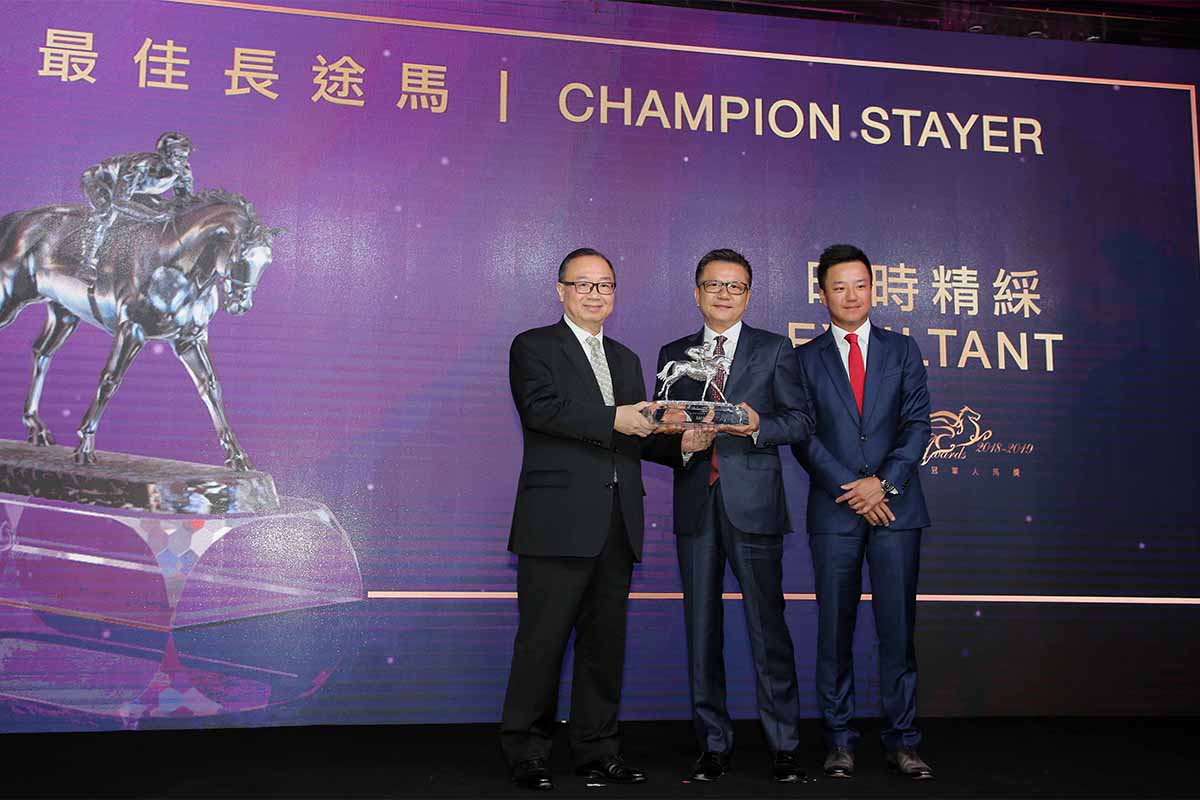 Exultant, owned by Mr. Eddie Wong Ming Chak and Mrs Wong Leung Sau Hing, won the Champion Stayer Award. The Hon. Martin Liao, Steward of The Hong Kong Jockey Club, presents the trophy to Mr. Eddie Wong Ming Chak, accompanied by his son Kirk Wong King Wai.