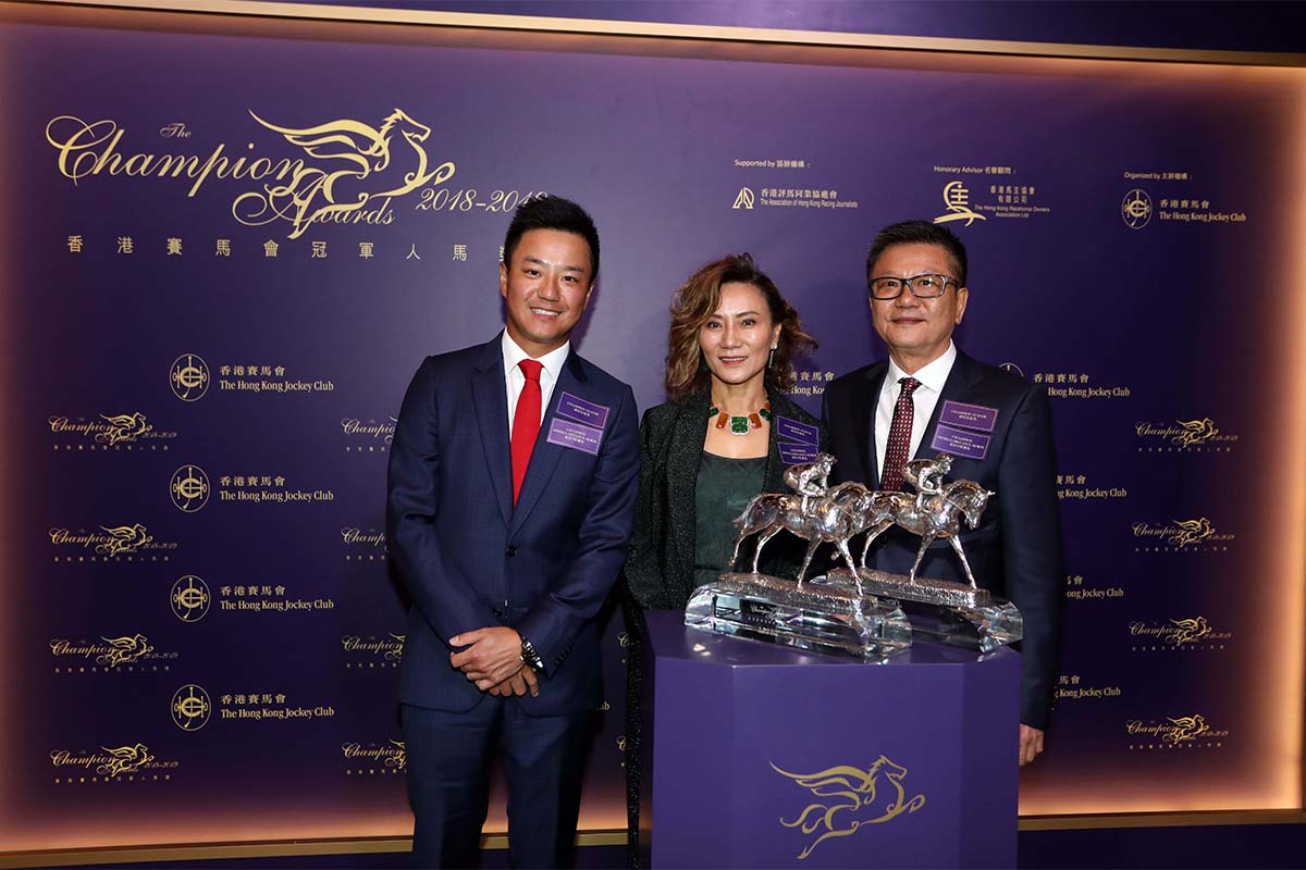 Exultant, owned by Mr. Eddie Wong Ming Chak and Mrs Wong Leung Sau Hing, won the Champion Middle-Distance Horse Award. Mr. Philip N L Chen, Steward of The Hong Kong Jockey Club, presents the trophy to Mr. Eddie Wong Ming Chak, accompanied by his son Kirk Wong King Wai. The Wong family celebrates after receiving the awards.